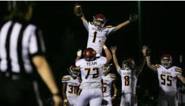 Players Kynan Sigua (#38), Jacob Brittain (#72), David Hair (#1), and Kaden Kunz (#8) celebrating a touchdown.