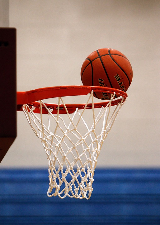 A basketball falling into a hoop.