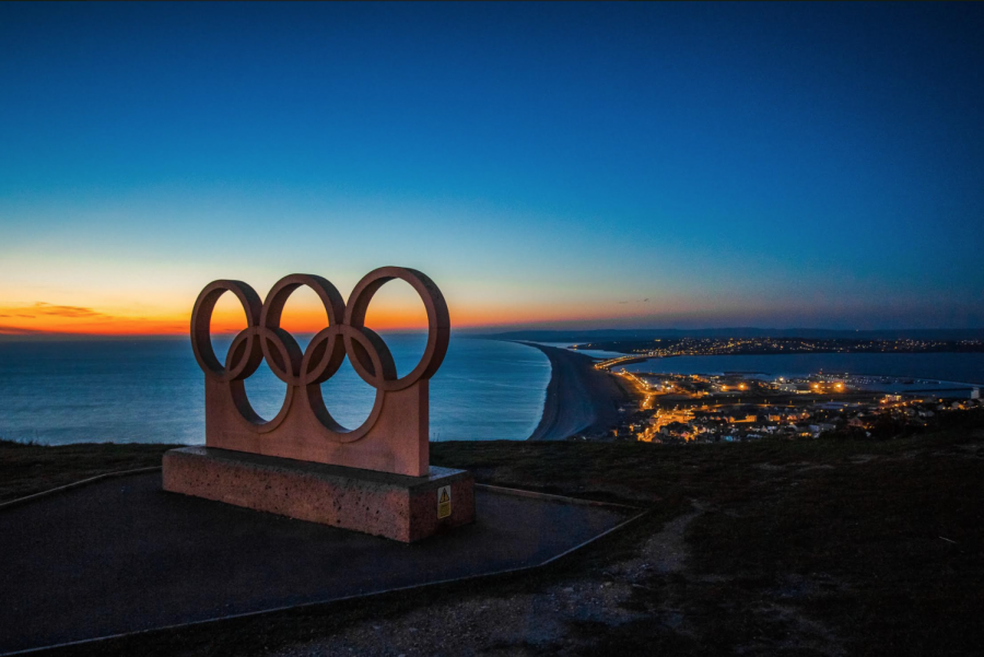 The Olympics symbol of five circles interlaced against a sunset backdrop.