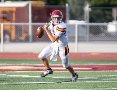Jackson McCarty roles to the right looking for his next pass during the game against Maple Mountain.